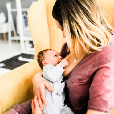 Mother looks at her baby breastfeeding