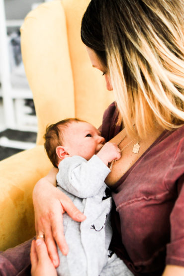 Mother looks at her baby breastfeeding