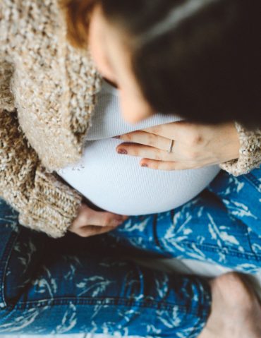 Expecting mother holds her belly