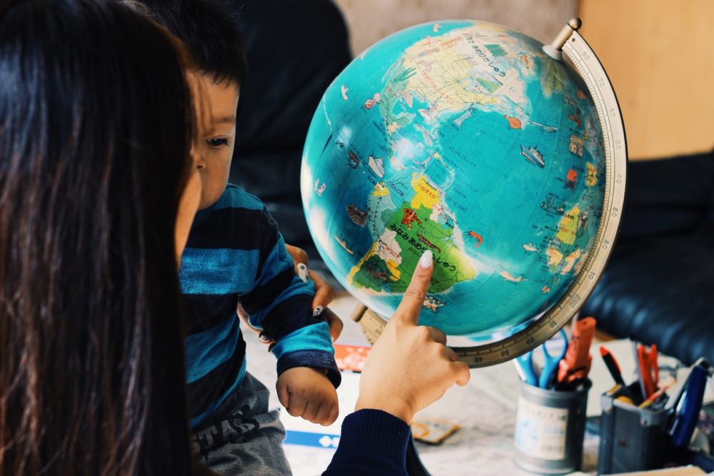 Mom points to globe holding son