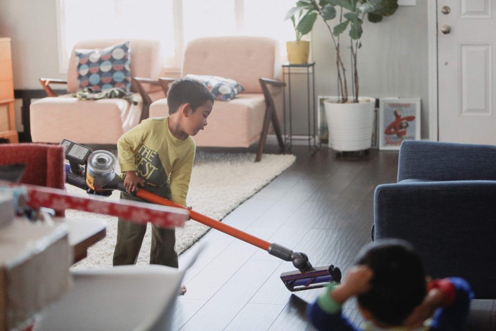 Young boy vacuuming the living room