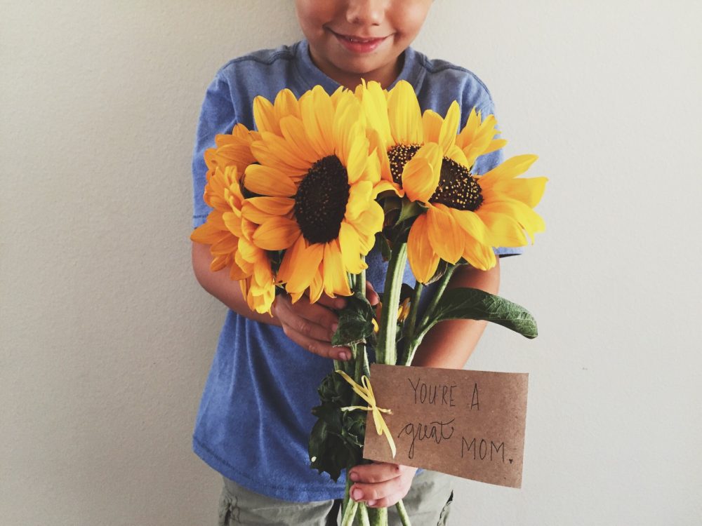 Boy holding flowers for mom