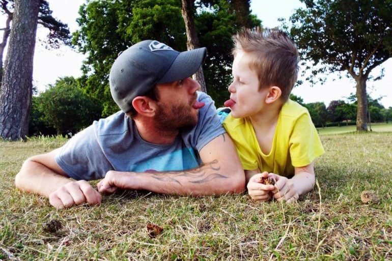 Father and son playing in a field. 
