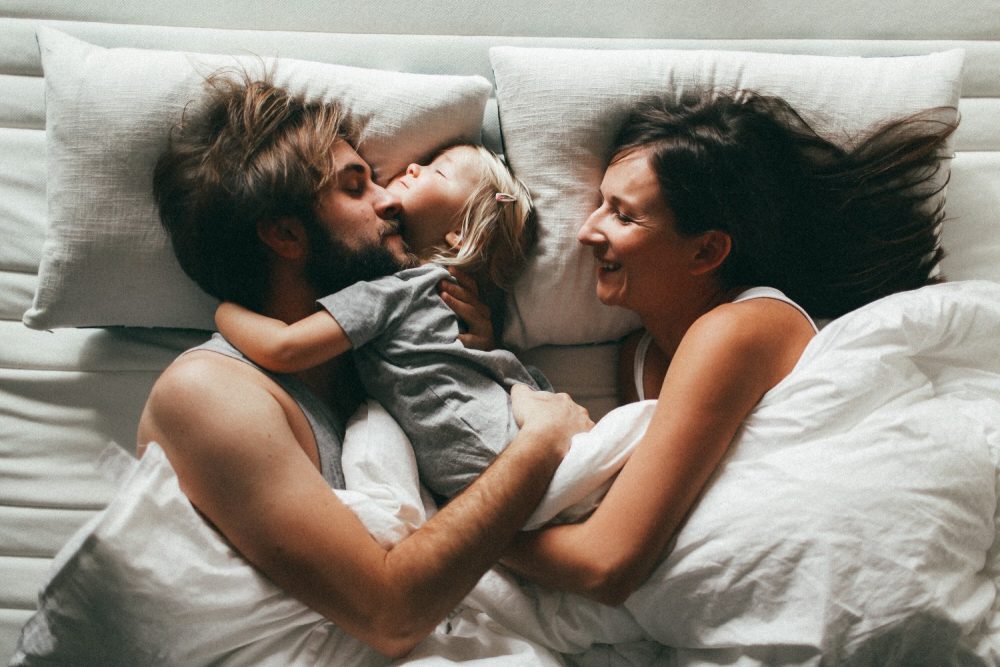 couple in bed with daughter