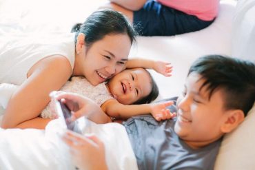 Family cuddling in bed