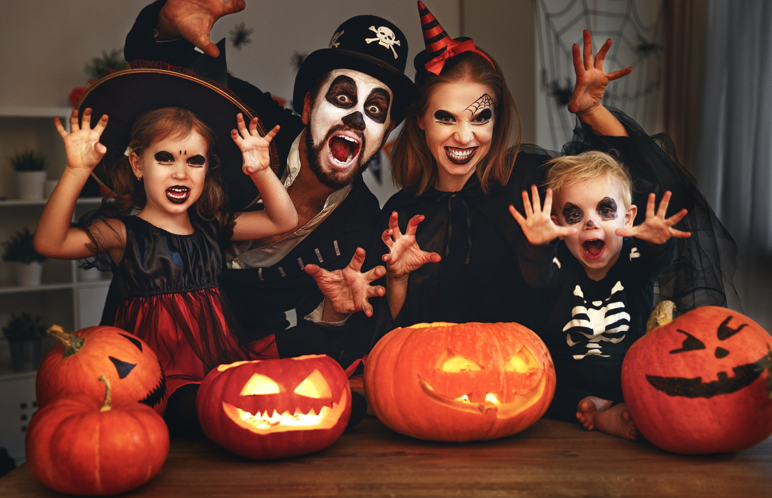happy family mother father and children in costumes and makeup on halloween