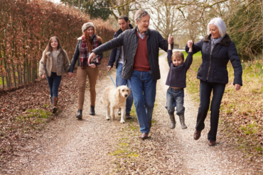 Whole Family out for a Walk with dog, Grand Parents Lifting child by the hands